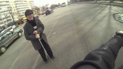 Мотоциклист помогает старому человеку перейти через дорогу